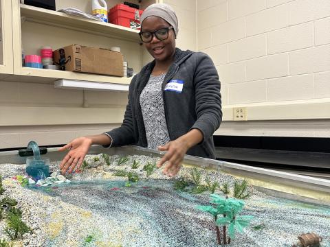Geosciences graduate student Amina Abdulsalam shows how streams impact the landscape using a stream table feature. Credit: Aagje Eijsink / Penn State. Creative Commons Geosciences graduate student Amina Abdulsalam shows how streams impact the landscape using a stream table feature. Credit: Aagje Eijsink / Penn State. Creative Commons