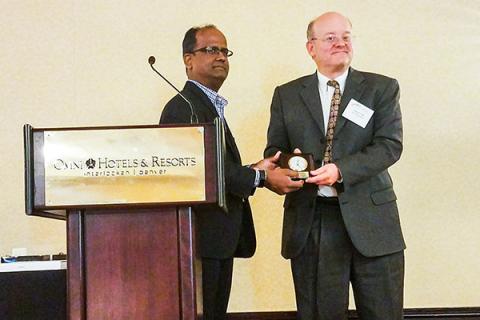 Kleit accepting award on stage.