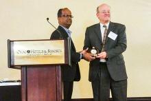Kleit accepting award on stage.