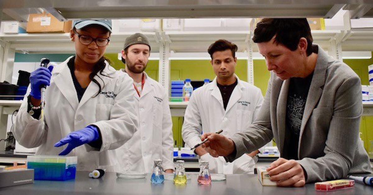 Deborah Kelly, far right, reviews lab results with students (left to right) Madison Evans, Michael Casasanta, and G.M. Jonaid. Photo taken September 2019. IMAGE: JAMIE OBERDICK